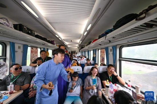 9月7日，相聲演員在S910列車上為旅客表演快板。
