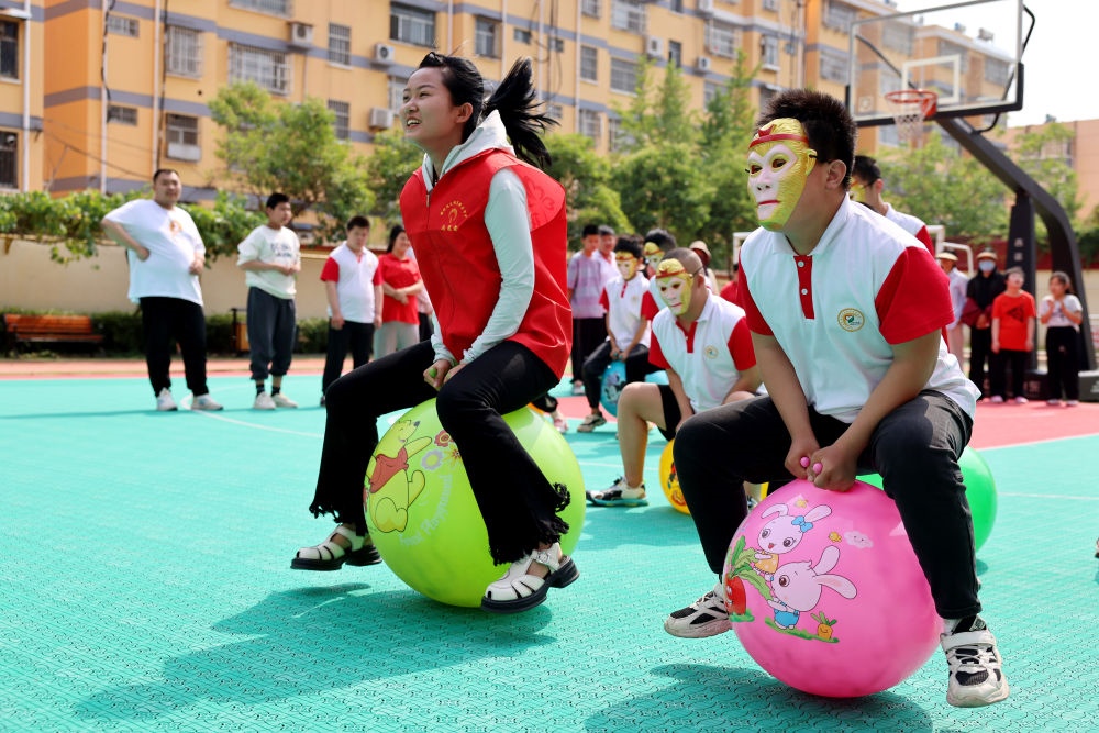 2024年5月17日，在山東省棗莊市市中區(qū)特殊教育中心，青年志愿者與智力障礙學(xué)生一起做游戲。新華社發(fā)（孫中喆攝）