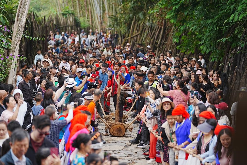 5月3日，各地游客在滄源縣翁丁村和村民一起參加佤族傳統(tǒng)民俗拉木鼓活動。（滄源縣融媒體中心供圖）