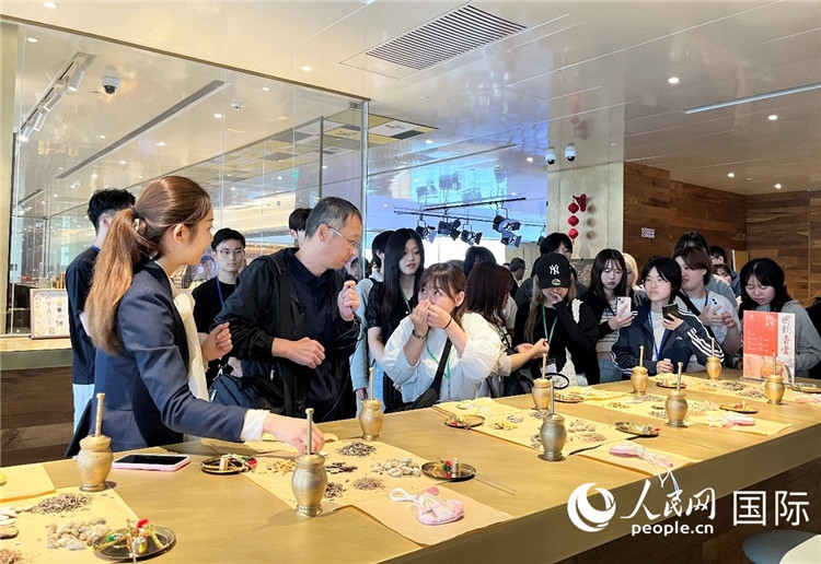 1. 日中友好協(xié)會青年代表團一行學(xué)習(xí)中醫(yī)香囊制作工序。（人民網(wǎng)記者陳思 攝）