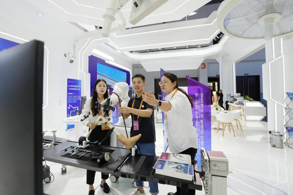 9月11日，一位媒體記者（中）在2024年服貿(mào)會(huì)國(guó)家會(huì)議中心會(huì)場(chǎng)體驗(yàn)北京納通科技集團(tuán)有限公司的膝關(guān)節(jié)置換手術(shù)機(jī)器人。新華社記者鞠煥宗 攝