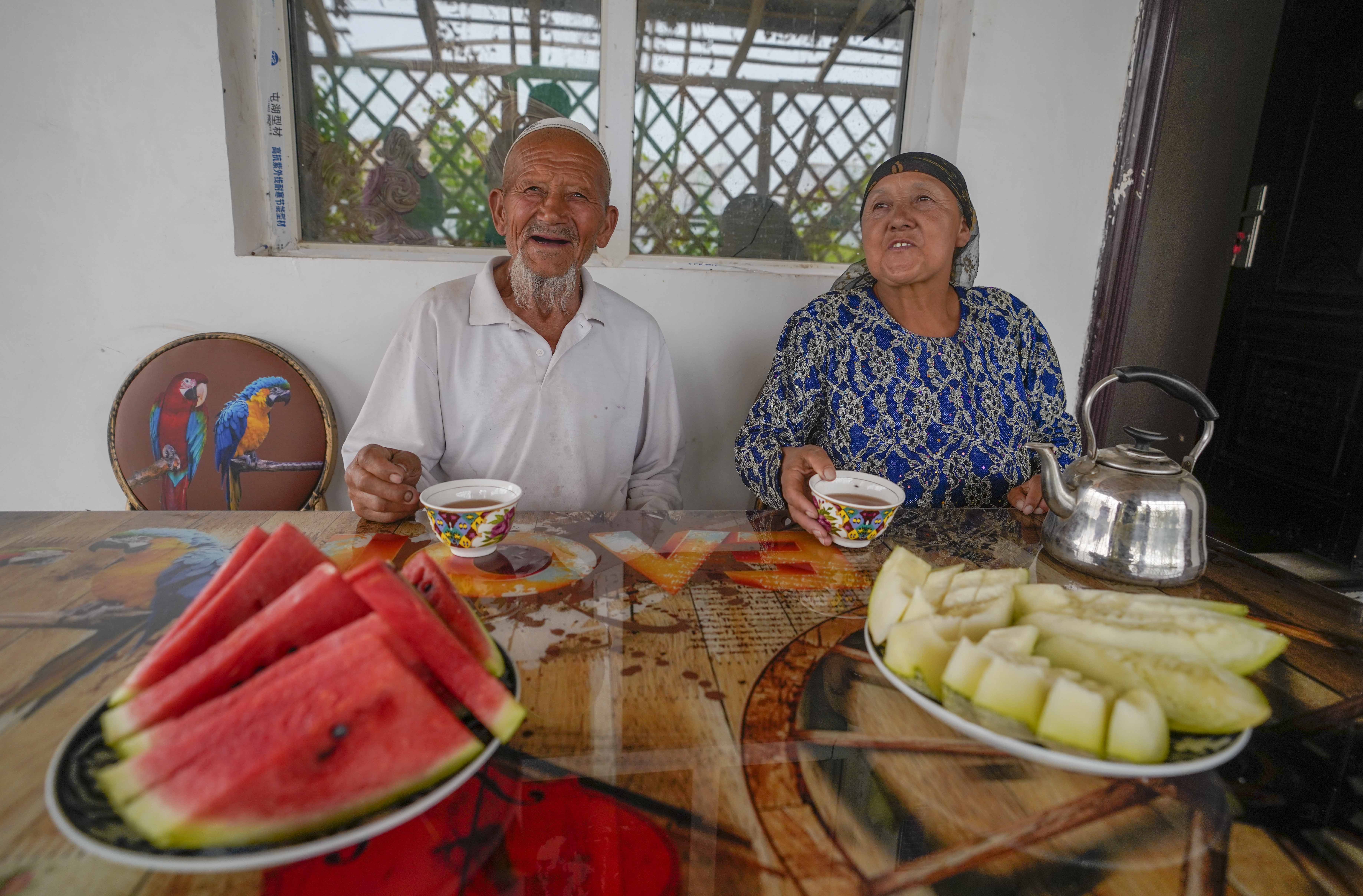 在新疆喀什地區(qū)伽師縣江巴孜鄉(xiāng)依帕克其村57號，80歲的維吾爾族老人伊米提·艾山（左）在自家庭院中（2020年6月8日攝）。