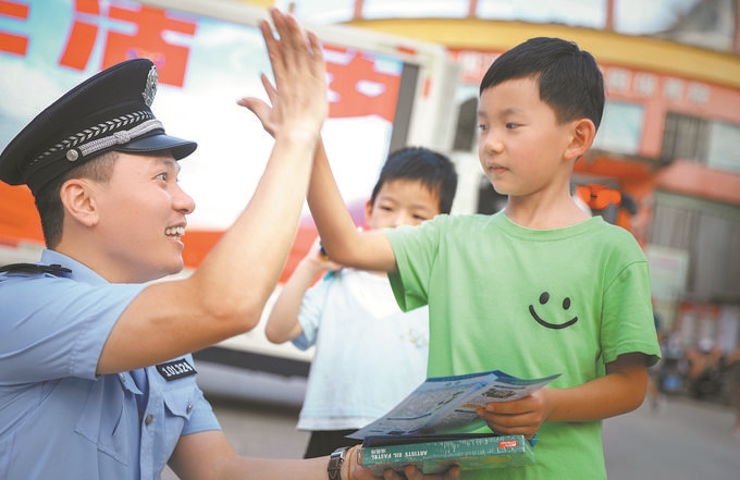 ▲7月10日，江西省吉安市公安局吉州分局組織民警深入轄區(qū)開展安全宣傳，民警向小朋友講解防溺水知識(shí)。朱文杰攝