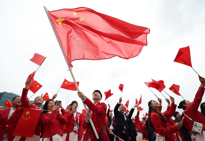 2024年7月26日，在法國巴黎舉行的第33屆夏季奧林匹克運(yùn)動會開幕式正式開始前，中國體育代表團(tuán)旗手揮舞國旗。新華社記者 曹燦 攝