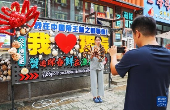 9月21日，游客在吉林省琿春市一處帝王蟹元素主題裝飾前拍照留念。新華社發(fā)