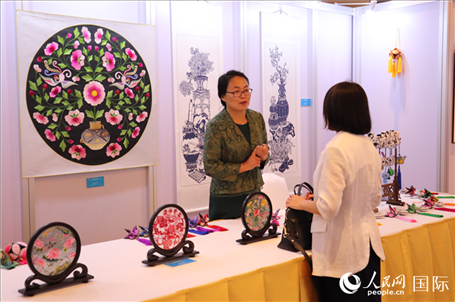 青海非遺文化傳承人向嘉賓介紹展品。人民網(wǎng)實(shí)習(xí)生姚欣可攝