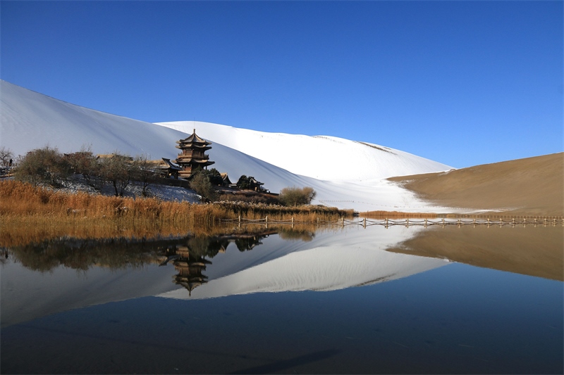 鳴沙山月牙泉景區(qū)雪景。敦煌市委宣傳部供圖，張曉亮攝