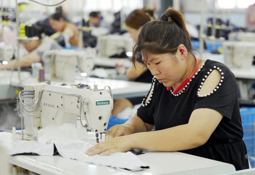 5月20日，村民在李寨村服裝加工廠內(nèi)忙碌。河南省周口市沈丘縣馮營鎮(zhèn)李寨村地處豫東平原。近年來，乘著脫貧攻堅與鄉(xiāng)村振興政策的東風，李寨村積極探索產(chǎn)業(yè)發(fā)展模式，通過“龍頭企業(yè)+村集體經(jīng)濟+農(nóng)戶”的方式，逐漸發(fā)展形成肉牛養(yǎng)殖、設(shè)施農(nóng)業(yè)、服裝加工、康養(yǎng)民宿等產(chǎn)業(yè)，以產(chǎn)業(yè)振興助力鄉(xiāng)村振興。新華社記者 李嘉南 攝