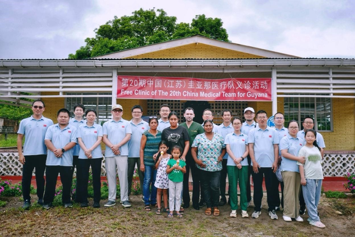 第20期中國（江蘇）援圭亞那醫(yī)療隊在圭偏遠的林登高速社區(qū)開展義診后，與部分當?shù)鼐用窈嫌啊?中國援圭醫(yī)療隊供圖