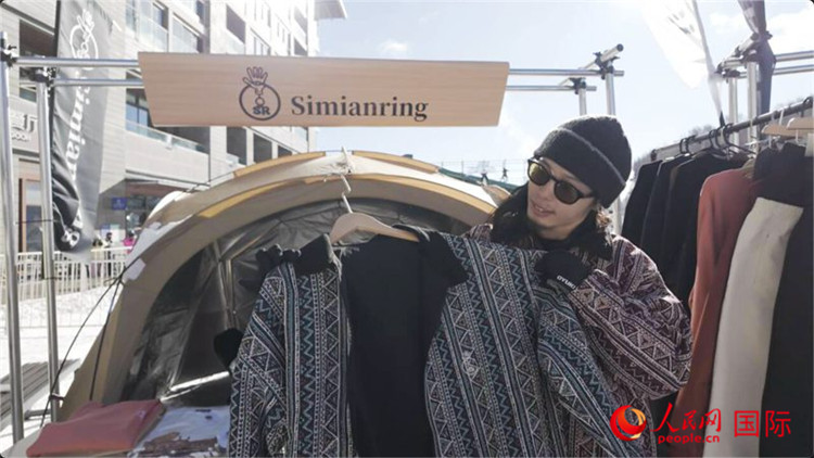 藤田周正在展示自己設(shè)計(jì)的滑雪服。人民網(wǎng)記者 袁蒙攝