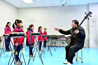 圖為12月30日，在惠民縣胡集鎮(zhèn)第一小學(xué)，老師指導(dǎo)學(xué)生學(xué)習(xí)西河大鼓。新華社記者 郭緒雷攝