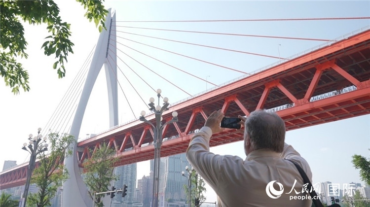 軻寶華“打卡”重慶東水門長江大橋。人民網(wǎng)記者 蘇纓翔攝