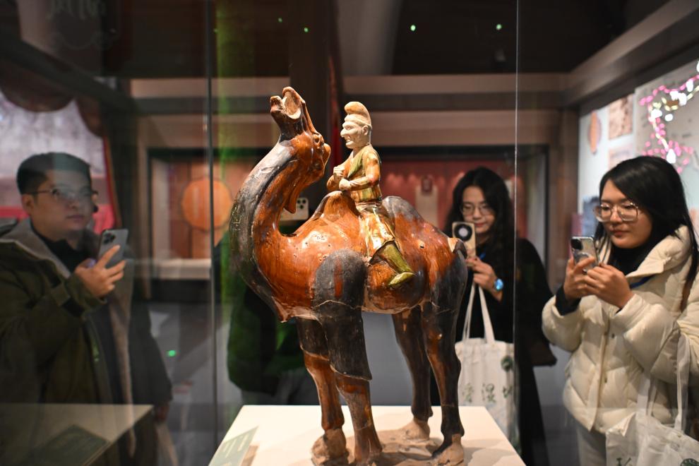 1月15日，觀眾在拍攝“長安三萬里——陜西唐代文物精華展”展出的三彩胡人騎駝俑。（新華社記者 孫凡越 攝）