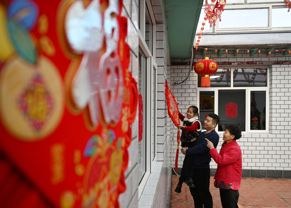 天津市西青區(qū)辛口鎮(zhèn)第六埠村村民在院子里掛“福”字（2024年2月1日攝）。新華社記者 趙子碩 攝