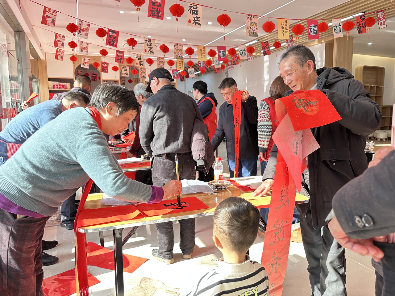 今年春節(jié)前夕，慶元縣濛洲街道同濟新村，一場送春聯(lián)活動熱鬧舉行。慶元縣融媒體中心 供圖