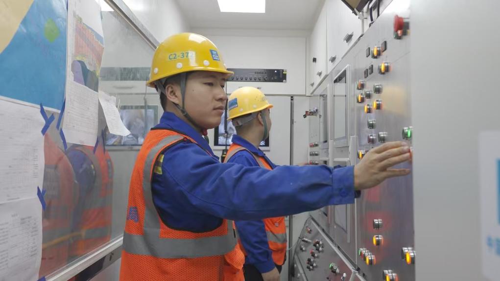 盾構司機何曉波在駕駛室內(nèi)調試盾構機參數(shù)。（劉芬攝）