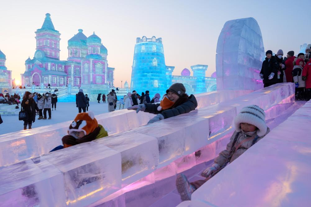 游客在哈爾濱冰雪大世界園區(qū)內(nèi)體驗冰滑梯。新華社發(fā)