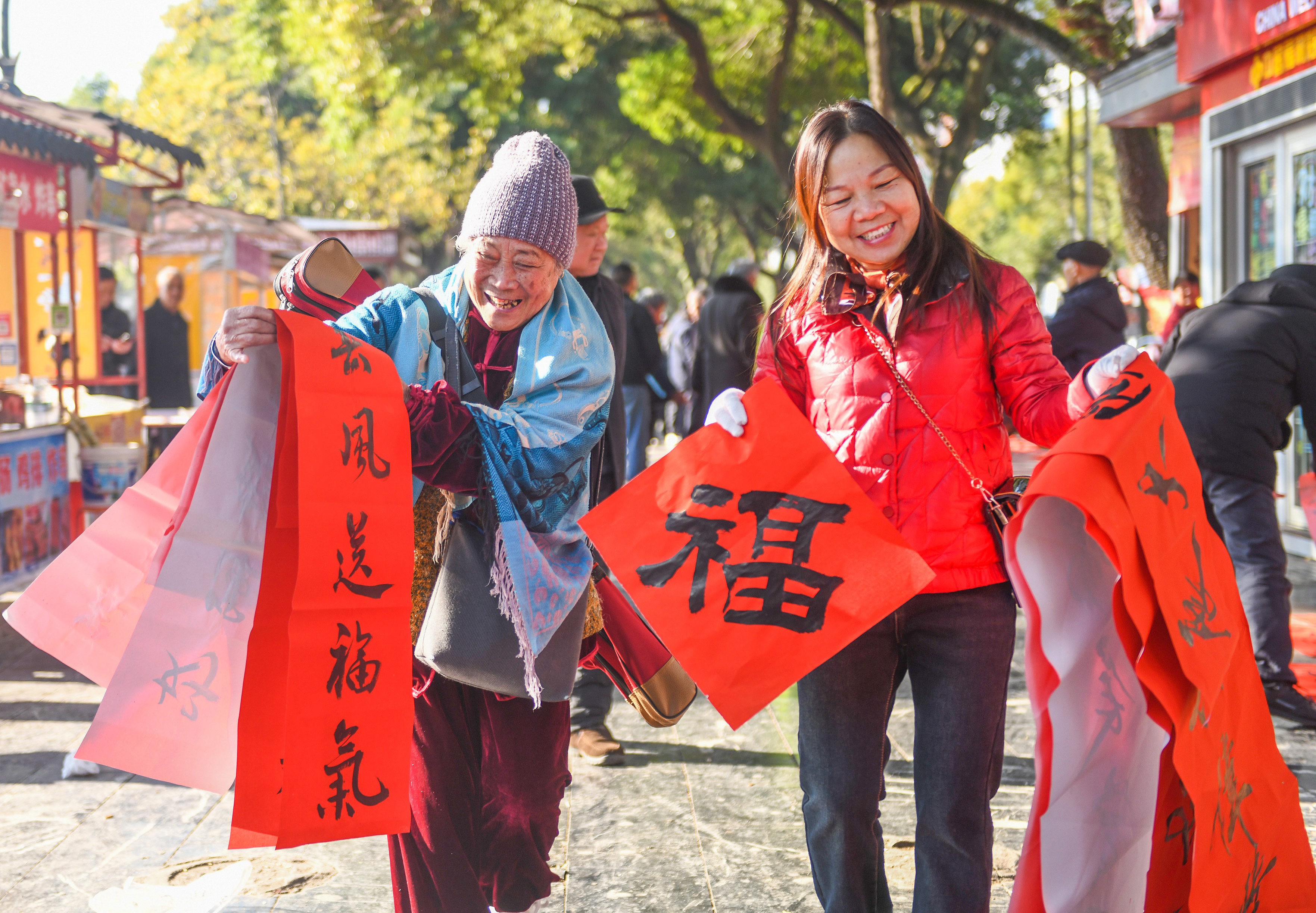 2025年1月13日，在湖南省永州市道縣西洲公園義工崗亭，市民們領到了書法志愿者為大家書寫的春聯。