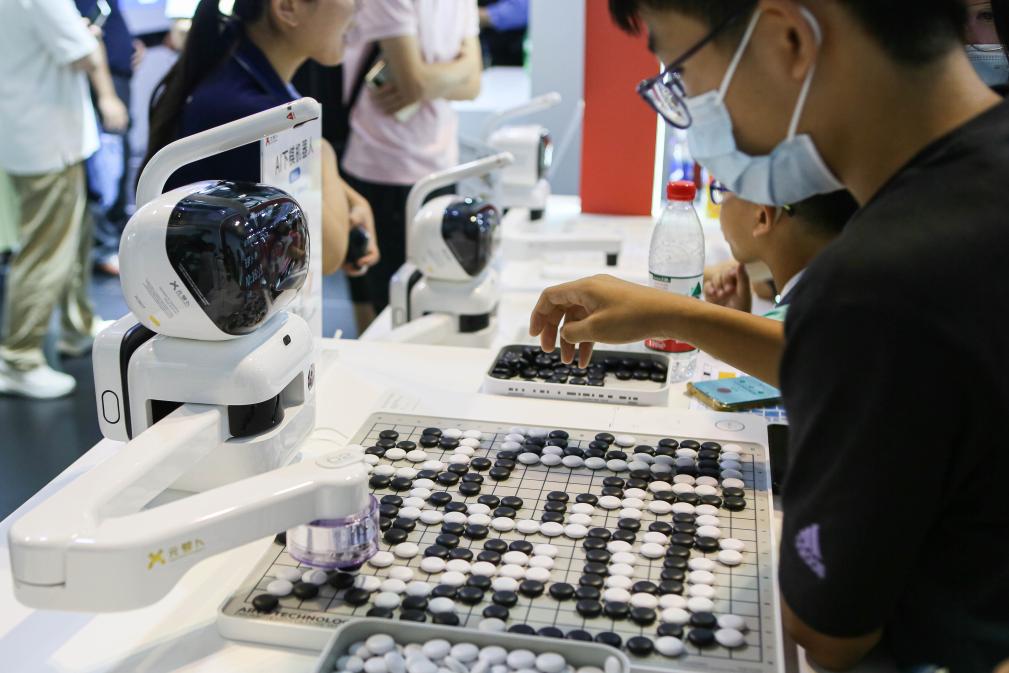 2023年7月7日，元蘿卜AI下棋機(jī)器人與觀眾對弈。2023年7月6日至8日，2023世界人工智能大會在上海舉行。新華社記者 辛夢晨 攝