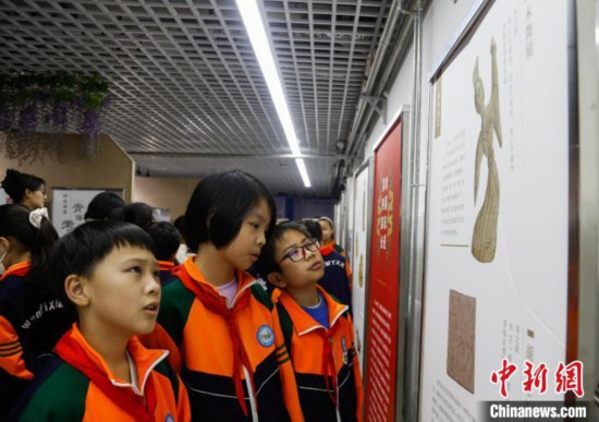 圖為學生參觀青海省博物館“1+3”主題流動展覽，了解木舞俑。中新社記者 馬銘言 攝