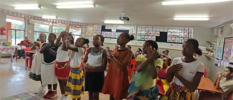 南非學(xué)生展示民族服飾，合唱《聽我說謝謝你》。