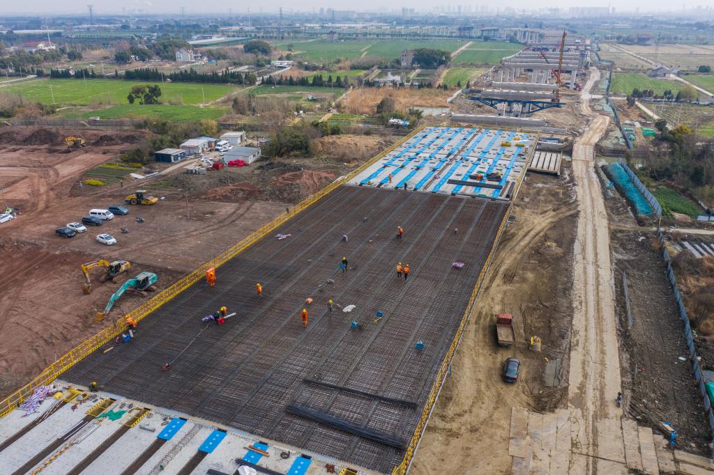 3月7日，在524國道秀洲王江涇至新塍公路工程TJ02標(biāo)段，作業(yè)人員正在進(jìn)行60米鋼混組合梁現(xiàn)澆橋面板鋼筋焊接及綁扎作業(yè)（無人機(jī)照片）。新華社記者 徐昱 攝