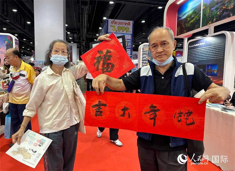 2025蛇年春節(jié)，泰國市民展示他們領(lǐng)到的華人手寫春聯(lián)。人民網(wǎng)記者 簡承淵攝