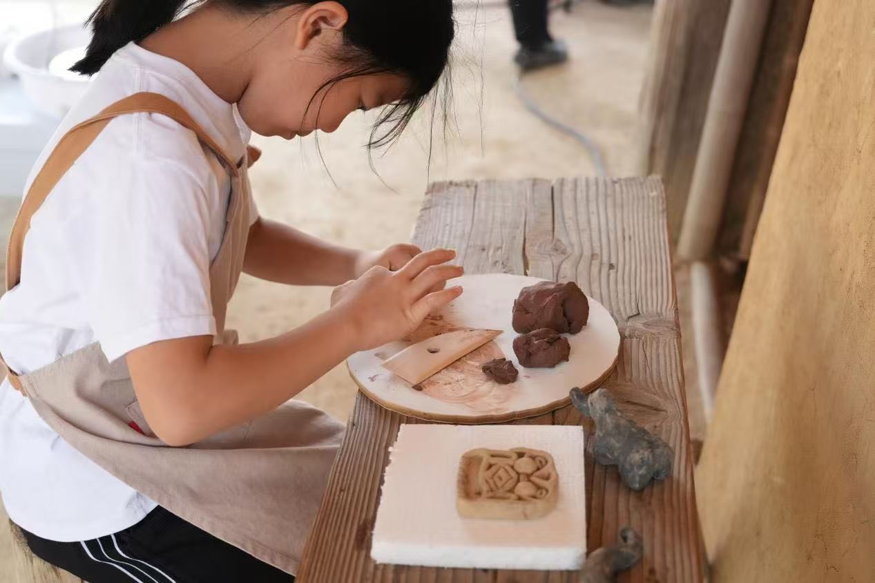 游客制作良渚特色陶藝品。良渚博物院供圖