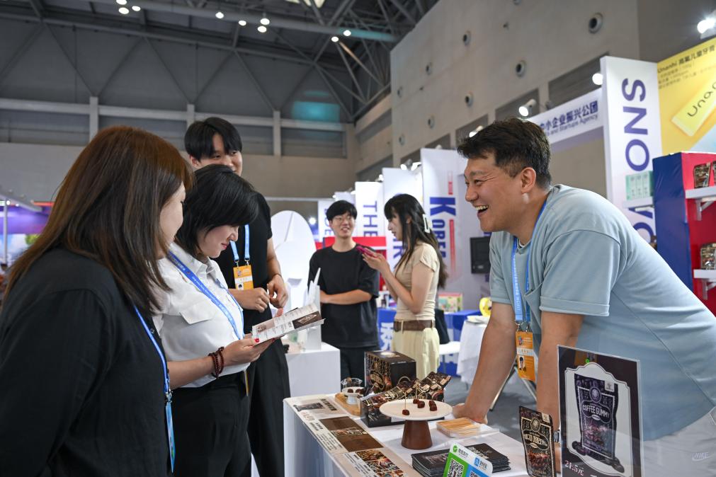 5月22日，韓國(guó)展商（右一）在西洽會(huì)現(xiàn)場(chǎng)向參觀者介紹產(chǎn)品。新華社記者 陳誠(chéng) 攝
