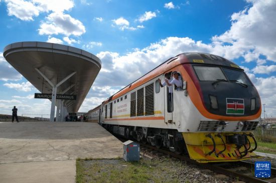5月31日，在蒙內(nèi)鐵路內(nèi)羅畢站，機(jī)車(chē)駕駛員蔣立平（右）和博爾在即將開(kāi)往蒙巴薩的E2次列車(chē)上揮手致意。新華社記者 楊光 攝
