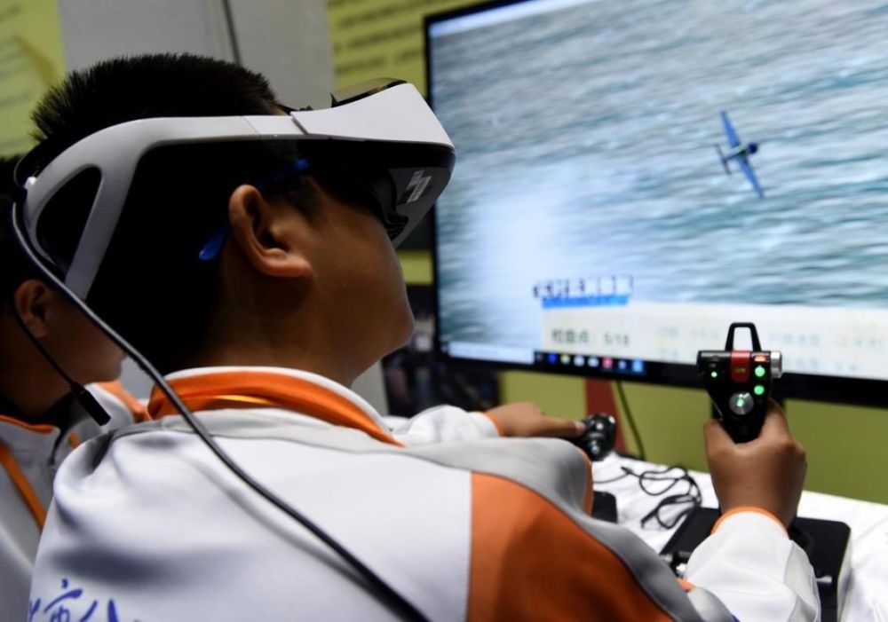 北京市八一學(xué)校的學(xué)生在北京市中小學(xué)生特色科技活動(dòng)展示上體驗(yàn)VR技術(shù)（2018年11月24日攝）新華社記者 羅曉光 攝。